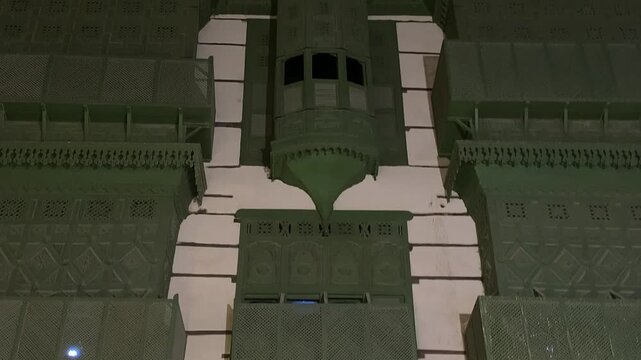 Editorial footage of the upper facade and traditional wooden rawasheen of Wali House (Bait Wali) in Al Balad Historic District, Jeddah, Saudi Arabia, captured at night in July 2026. A remarkable examp