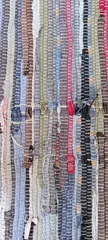 Neutral woven rag rug texture made from recycled fabric strips. Handmade textile background with soft gray, blue and beige tones, visible stitching, rustic craftsmanship and © Elena