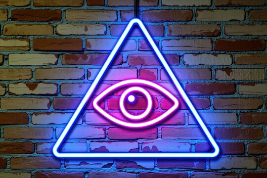 Neon seeing eye sign glows inside triangle shape on rough brick wall background. Blue, pink light illumination create mystical atmosphere. Concept involves conspiracy theories secret societies