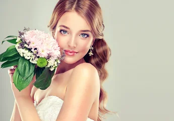 Fashion blonde bride girl  in gorgeous wedding dress with wedding bouquet of flowers © Sofia Zhuravetc