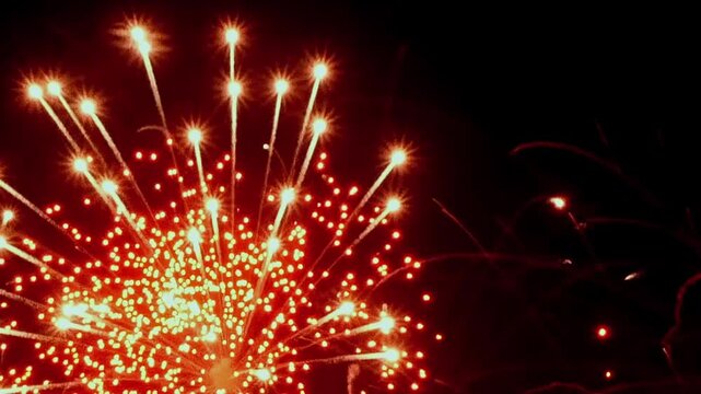 Spectacular golden fireworks illuminate the night sky. Bright sparks dance in celebration of Christmas and the arrival of the New Year. Bursts of light paint a vibrant picture.