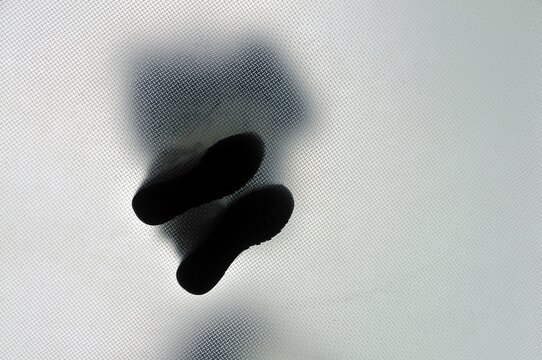 Anonymous person standing with legs crossed, from below