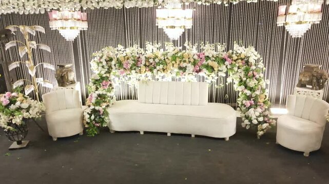 Elegant white wedding stage setup with floral arch chandeliers sofa and decorative backdrop for romantic celebration events with displays luxurious wedding