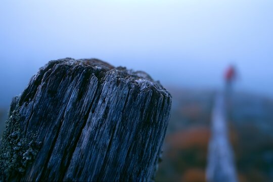 Rustic wooden post with blurred blue hour valley backdrop