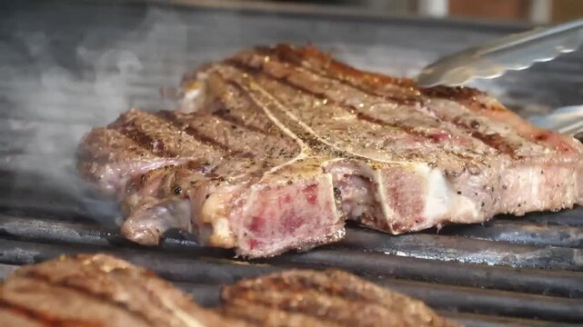 A succulent beef T-bone steak cooking on a hot charcoal grill, showing distinct sear marks and sizzling fat. Perfect for themes of summer outdoor cooking, gourmet dining, and high-quality protein meal