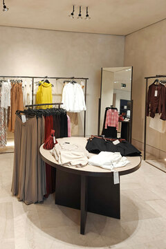 Modern fashion boutique store interior with clothing racks and mirror