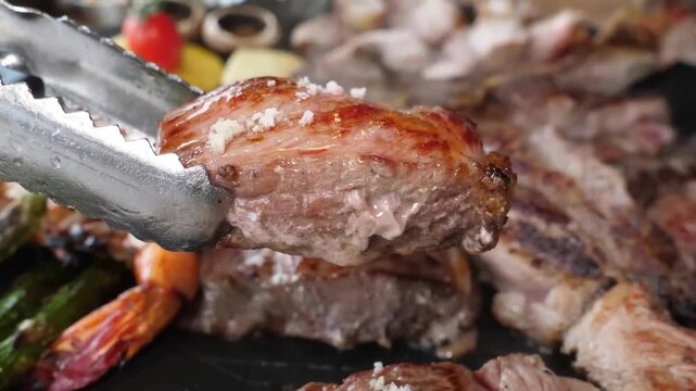 High-quality footage featuring a thick, juicy beef steak sizzling on a hot barbecue grill. The scene highlights the glistening meat texture, charred crust, and rising smoke as the steak is lifted with