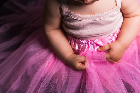 Baby girl learning ballet, dressing up in pink tutu