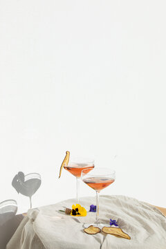 Two rose wine glasses with summer cocktails and dried fruit appetizers