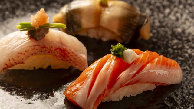 Premium nigiri sushi with fresh salmon and white fish arranged on dark slate plate