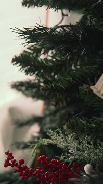 Close-up of hands hanging an ornament on a christmas tree
