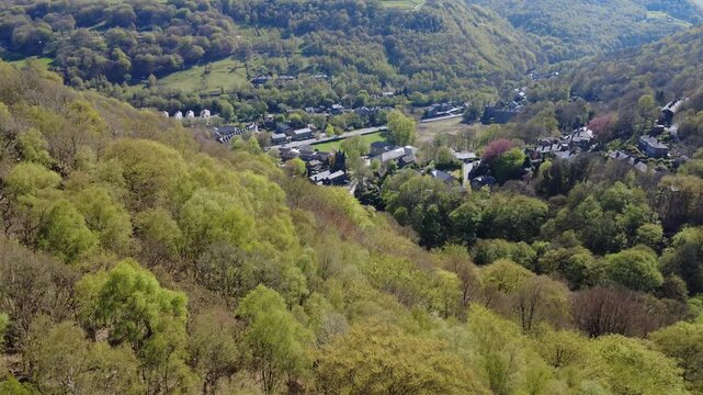 high aerial view of Mytholm at the end of Hebden Bridge in West Yorkshire in bright spring sunlight under a wooded hillside