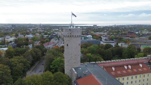 View of Tallinn's Old Town with towers, rooftops, and flag from a tower in Estonia during daytime.Tall Hermann is the defensive tower standing at the southwestern corner of Toompea Castle in Tallinn.