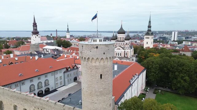 View of Tallinn's Old Town with towers, rooftops, and flag from a tower in Estonia during daytime.Tall Hermann is the defensive tower standing at the southwestern corner of Toompea Castle in Tallinn.