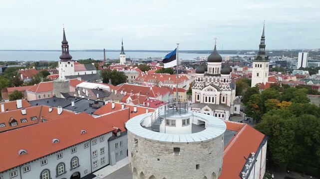 View of Tallinn's Old Town with towers, rooftops, and flag from a tower in Estonia during daytime.Tall Hermann is the defensive tower standing at the southwestern corner of Toompea Castle in Tallinn.