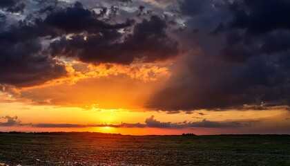 Fototapeta premium Dramatic Sunset With Vibrant Orange Hues And Dark Storm Clouds In The Sky