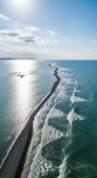 Aerial view of a long sandy beach meeting the ocean waves.