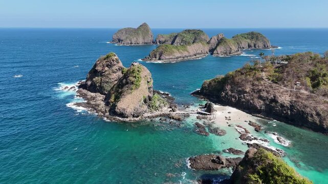 Stunning aerial footage of steep rocky cliffs and tropical islets surrounded by crystal-clear turquoise ocean waters