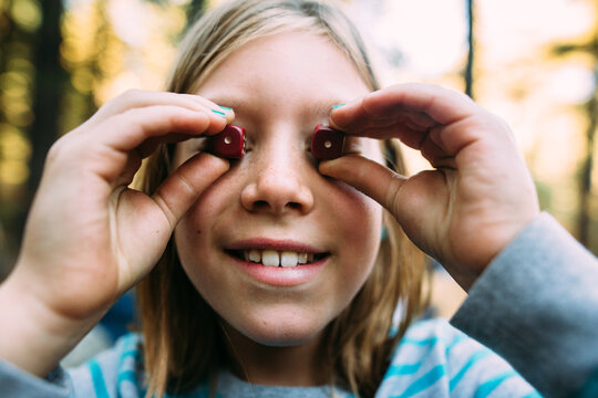 Girl Holding a Pair of Dice to her Eyes