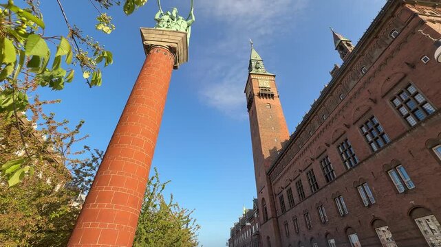 Low angle of City Hall tower and Lur Blowers column, Copenhagen city, Denmark