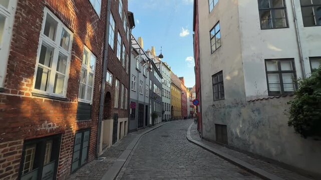 Narrow cobblestone street with old colorful buildings in Copenhagen, Denmark