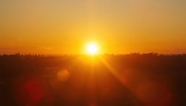 Sunset illuminates the horizon with a brilliant golden glow while casting long shadows over the distant landscape.