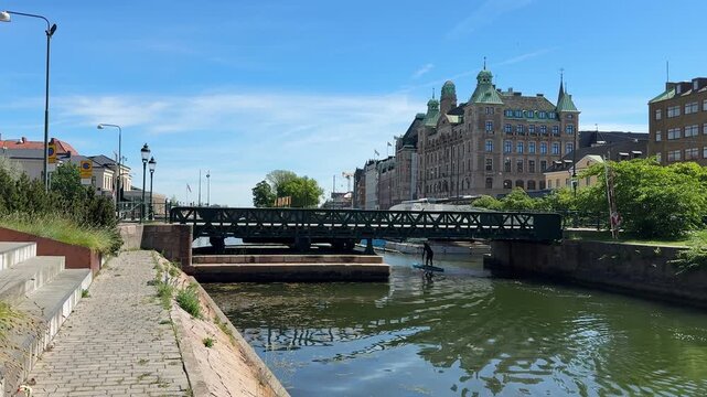 Malmo city canal and historic buildings with paddleboarder, Sweden