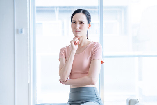 考えるピラティスの格好をした女性