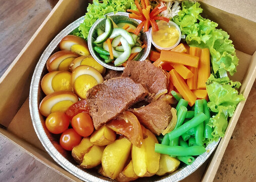Top view of healthy meal box with braised beef eggs vegetables and potatoes. Balanced diet lunch in catering box. Clean eating and meal prep concept.