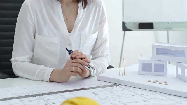 Architect hands working on building blueprint, analyzing design with scale model structures, developing urban planning and innovative construction project ideas