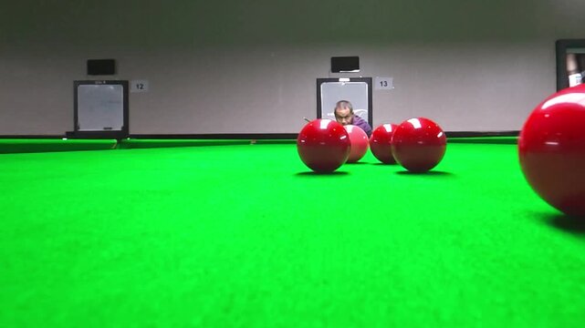 Slow motion of a snooker player taking a shot, in club Chiangmai Thailand.