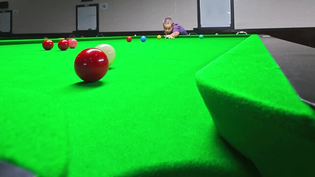 Slow motion of a snooker player taking a shot, in club Chiangmai Thailand.