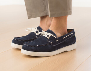 Naklejka premium Close-up Action View of Feet in Dark Blue Loafers on Light Wooden Floor with Khaki Pants in Clean Environment