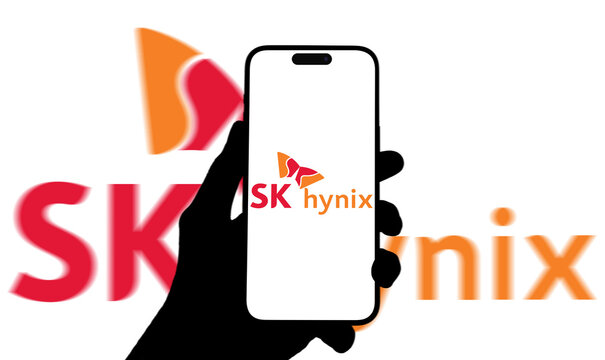 SK Hynix Logo Displayed on Smartphone Screen Held in Silhouette Hand Against Large Blurred SK Hynix Wordmark Background