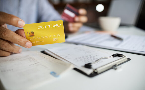 close-up shot, man hand holding credit card calculate expenses from receipt and bills before paying credit card debt