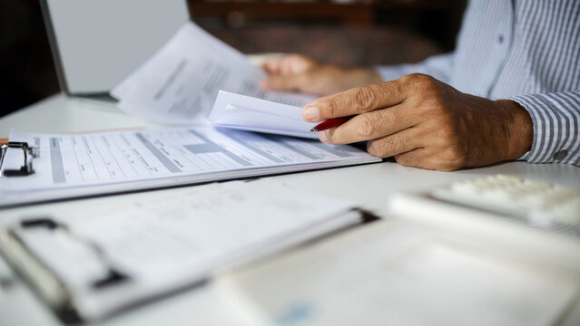 close-up shot, businessman work on desk reviewing business contract and verify the accuracy of the document