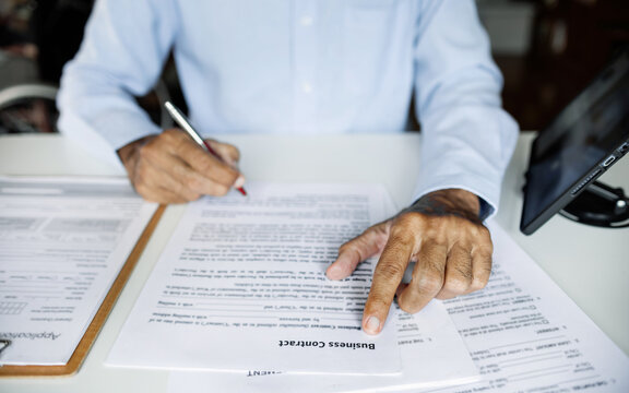 close up shot, asian businessman working on desk verify of business contract before signing to make new business
