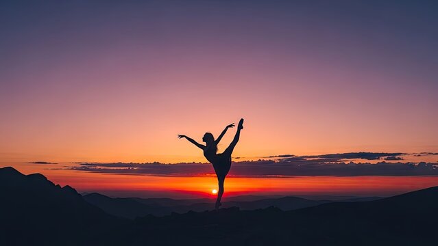 Silhouette of a ballerina performing at sunset in mountains.
