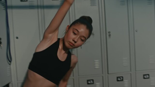 Teenage Girl Executes Body Side Bend Exercise. Holding Fitness Rubber Band High Above Head With Full Arm Extension, Focuses on Strengthening Core Muscles. Healthy Lifestyle Among Generation Z.