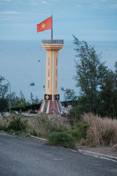 Vietnamese national flag fluttering in the wind on the tall flagpole of Ly Son Island