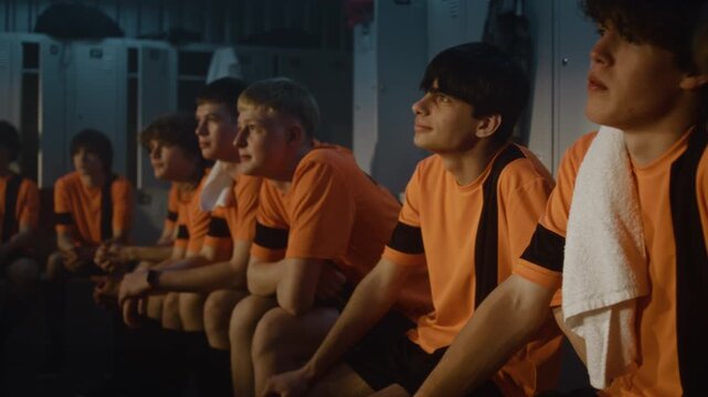 In Locker Room, Diverse Group of Teenage Boys Sits Absorbed in Theoretical Session With Mentor. Concept of Sport Education, Disciplined Listening, Development of Character Through Athletic Training.