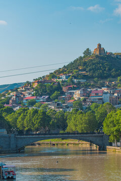 Metekhi church on hill with Kura river and bridge in Tbilisi with copy space