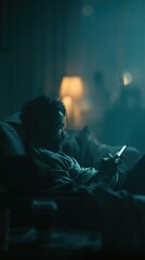 Obraz premium A Contemplative Evening: A Young Man Engrossed in His Phone in a Dimly Lit Room