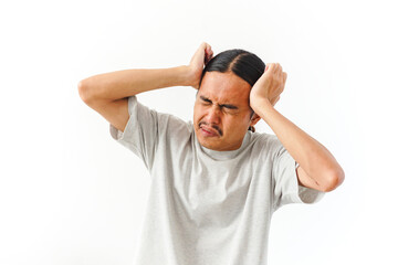 Fototapeta premium A man with long dark hair clutches his head in evident pain or distress against a clean white background.