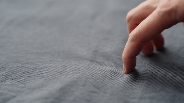 man manually check corduroy blue color cotton fabric for clothing with hands