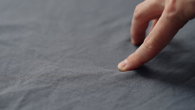 man manually check gray blue color cotton fabric for clothing with hands