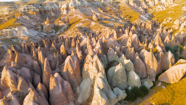 Goreme, Nevsehir, Turkey. Dreamlike landscape of Devrent Valley at sunset with whimsical stone figures and colorful geological patterns from above.. Aerial View