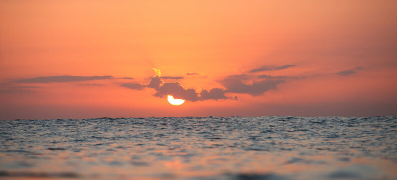 Beautiful Orange Sunset Over Rippling Ocean Horizon at Twilight