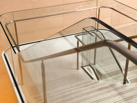 Modern stainless steel and glass staircase with safety handrails and geometric shadow patterns