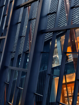 Triangular black building facade dominating plaza showcasing perforated metal cladding